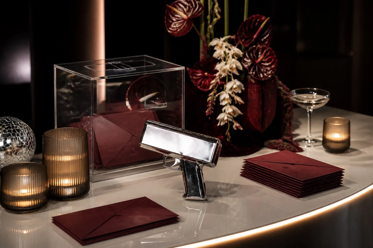 Refined money table with a clear collection box, burgundy envelopes, and candlelight